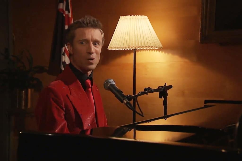 Sammy J singing at the Butterfly Club with a lamp