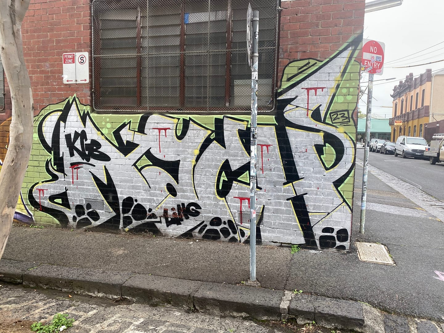 nice grafitti in white and lime green on a red brick wall