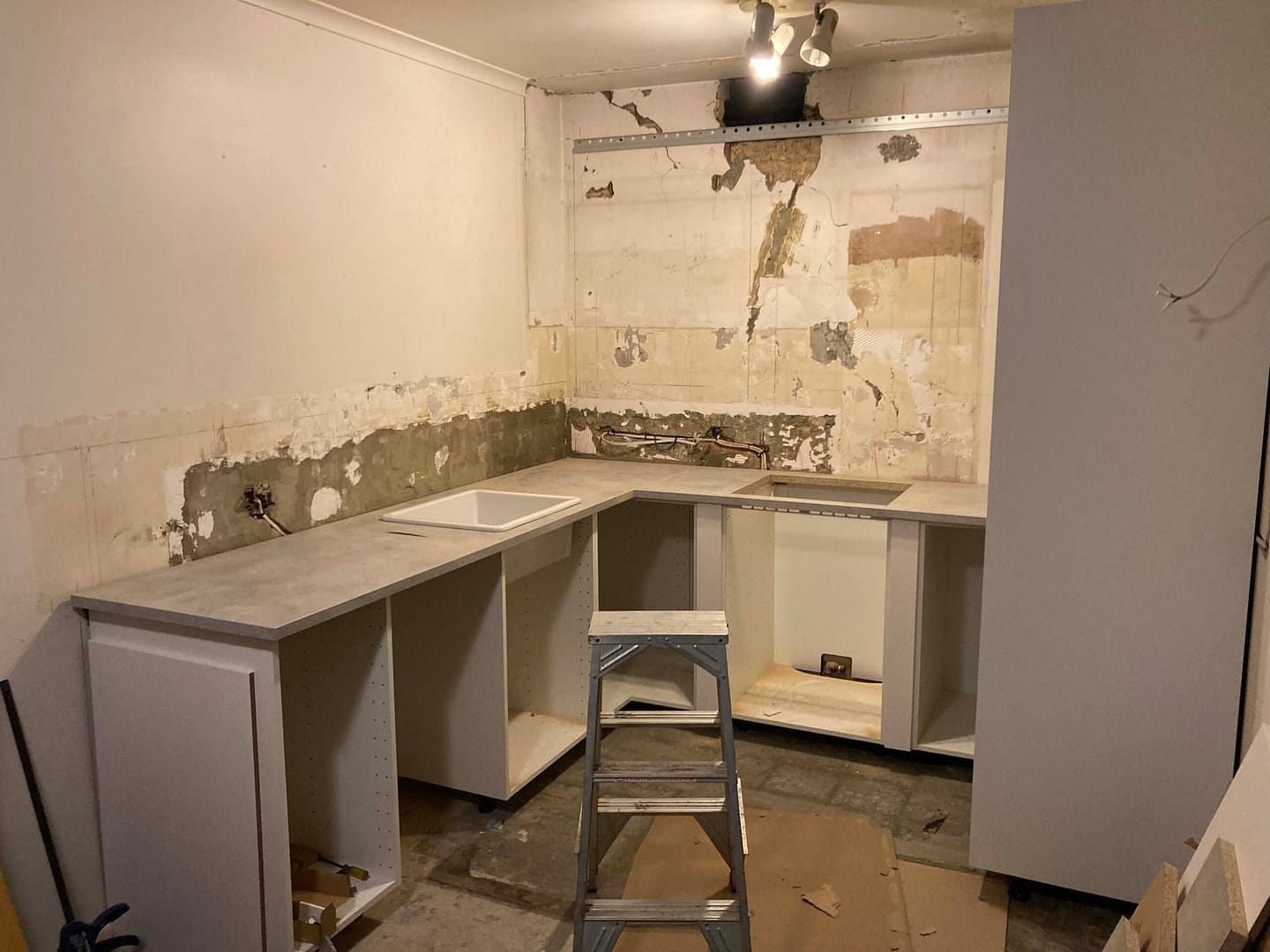 kitchen renovation with grey concrete benchtop and cabinets underneath